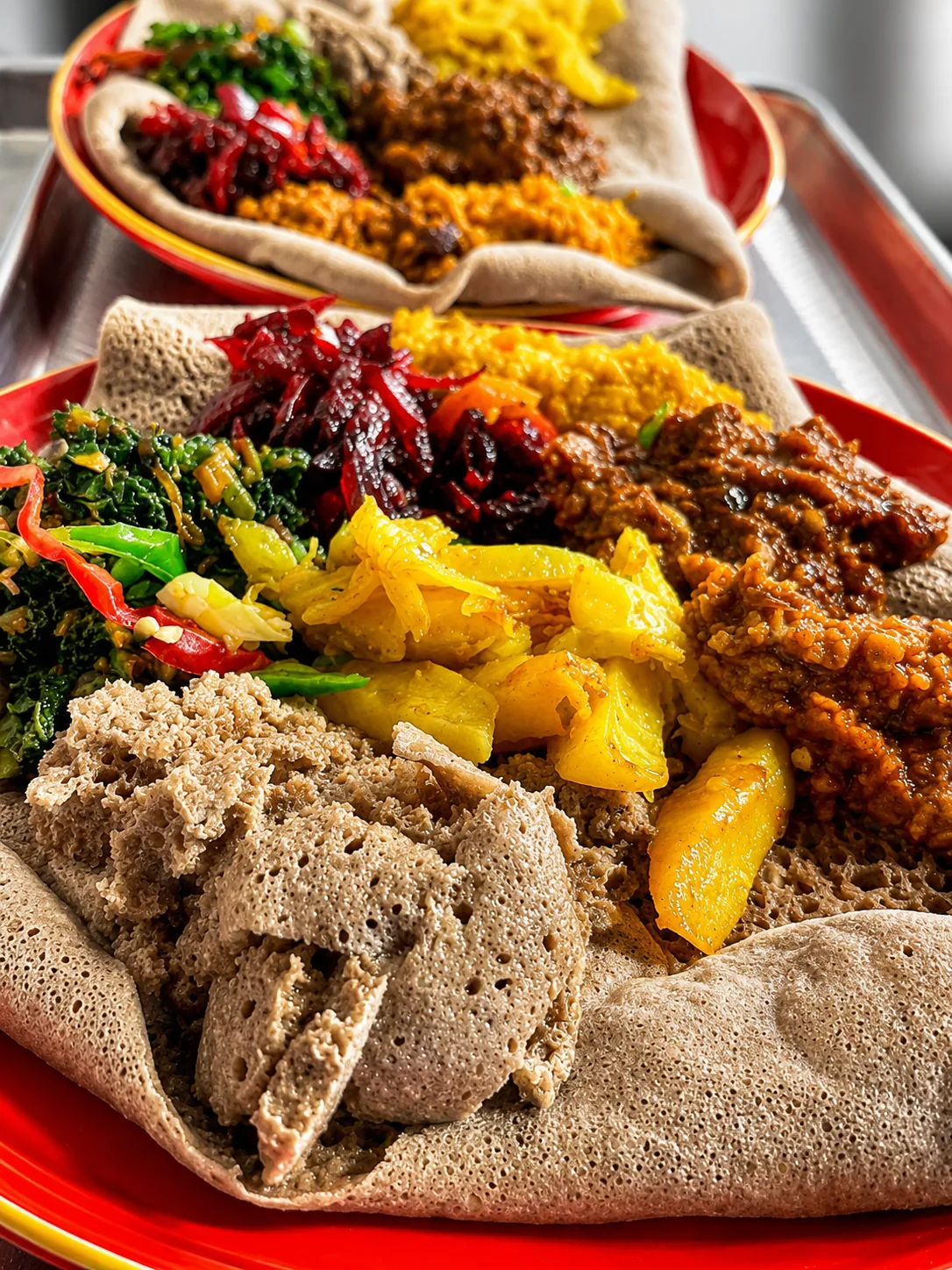 Two colourful Ethiopian platters served with injera